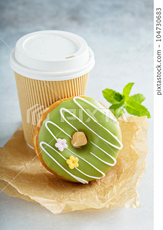 Green matcha glazed donut with cherry 104730683