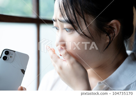 Young woman shocked by breaking her smartphone 104735170