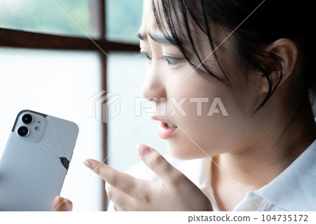 Young woman shocked by breaking her smartphone 104735172
