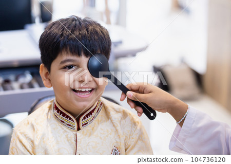 Indian boy examining eyesight checkup vision farsightedness examines ophthalmological hospital. Indian boy examining eyesight checkup vision farsightedness examines ophthalmological hospital. 104736120
