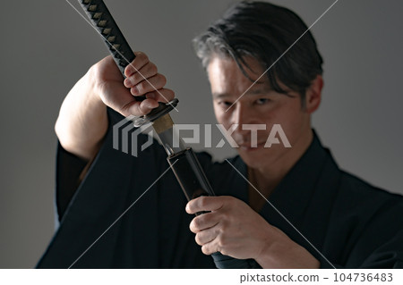 一個拿著日本刀的男人 黑色背景 104736483