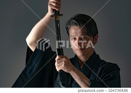 A man with a Japanese sword Black background A man with a Japanese sword Black background 104736486