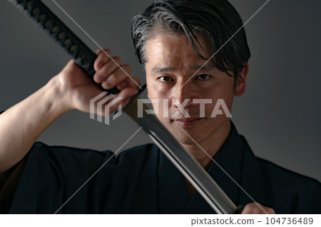 一個拿著日本刀的男人 黑色背景 104736489