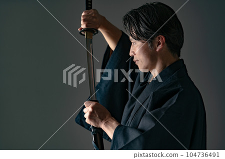 一個拿著日本刀的男人 黑色背景 104736491