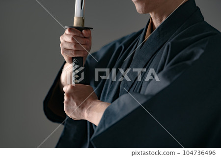 一個拿著日本刀的男人 黑色背景 104736496