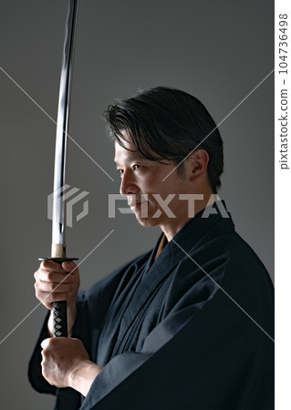 一個拿著日本刀的男人 黑色背景 104736498