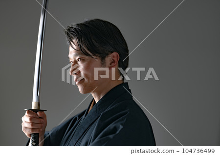 一個拿著日本刀的男人 黑色背景 104736499