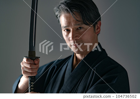 一個拿著日本刀的男人 黑色背景 104736502