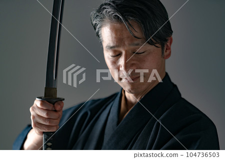 一個拿著日本刀的男人 黑色背景 104736503