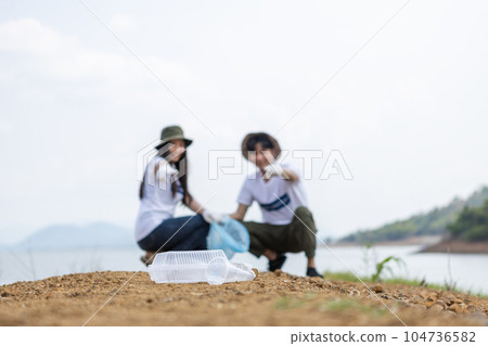 Close up Garbage plastic with blur male and female volunteers background. 104736582