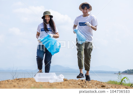 Male and female volunteers running to pick up plastic garbage Male and female volunteers running to pick up plastic garbage 104736583