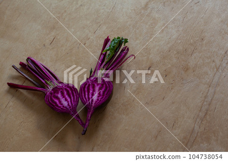 Halves of raw beet on wooden table. 104738054
