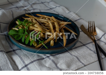Roasted char-grilled green beans with fresh arugula 104738056