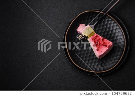 Delicious sweet dessert cheesecake with raspberry and pistachio flavor 104739652
