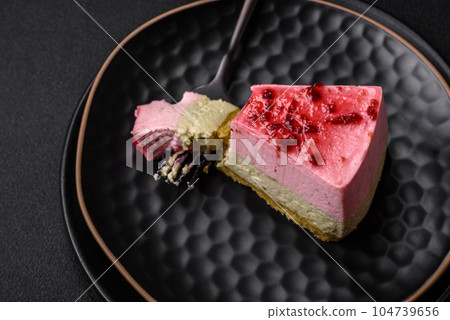 Delicious sweet dessert cheesecake with raspberry and pistachio flavor 104739656