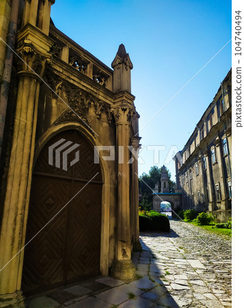 two-leaf wooden door under a semicircular arch of stone two-leaf wooden door under a semicircular arch of stone 104740494
