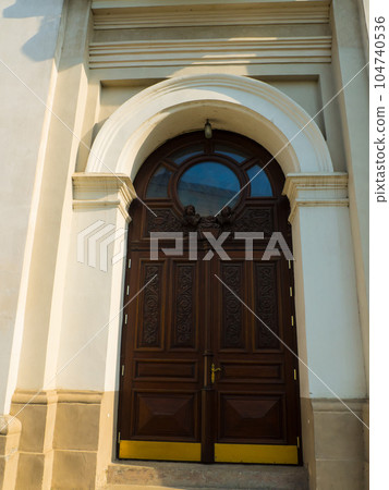 ornate entrance to the old church with two wooden angels ornate entrance to the old church with two wooden angels 104740536