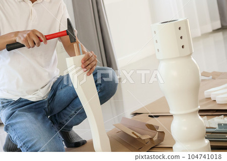 Man assembling furniture at home Man assembling furniture at home 104741018