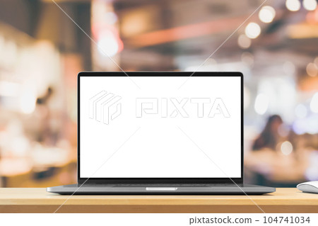 Laptop with blank screen on wood table with cafe coffee shop blur background 104741034
