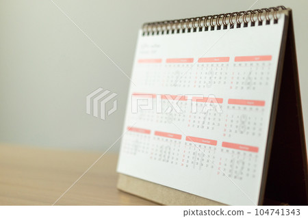 Calendar page close up on wood table with white wall background business planning appointment meeting concept 104741343