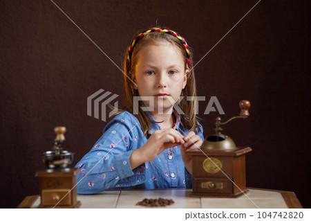 Portrait of a girl with a retro coffee grinder. Grunge photo. Portrait of a girl with a retro coffee grinder. Grunge photo. 104742820