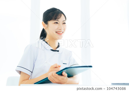 A female medical worker interviewing a patient A female medical worker interviewing a patient 104743086