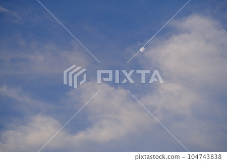 Morning blue skies, faint clouds, and the moon behind them Morning blue skies, faint clouds, and the moon behind them 104743838
