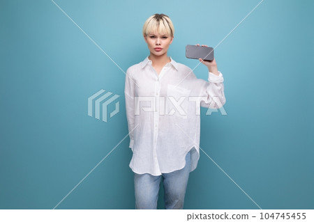 young smart blond career woman in a white shirt shows ads on a smartphone with a mockup. business 104745455