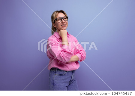 smart young blond businesswoman in a pink shirt and jeans is confident in her business on a studio smart young blond businesswoman in a pink shirt and jeans is confident in her business on a studio 104745457
