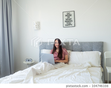 woman working with laptop on the bed 104746108