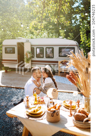 Beautiful wedding couple laugh and kiss relaxing in rv, camping in a trailer. Romantic moment. 104746235