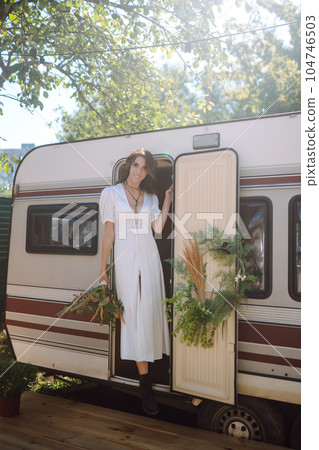 Beautiful stylish bride near trailer. Camping season. Marriage. Happy newlywed woman. Beautiful stylish bride near trailer. Camping season. Marriage. Happy newlywed woman. 104746503