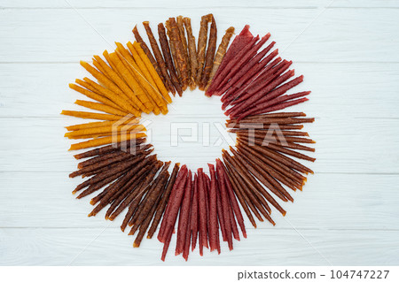 Sweet pureed fruit pastille. Fruit roll-ups homemade. Natural sweets from dried berries and fruits. mix of raspberries, currants, apples, bananas, strawberries, plums, pumpkins. healthy snack concept 104747227