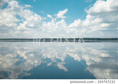 Fantastic landscape. Clouds and the river. Mirror water. blue lake with cloudy sky, nature series. road in clouds 104747232