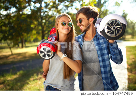 Young man and woman riding on the Hoverboard in the park. content technologies. a new movement. 104747499