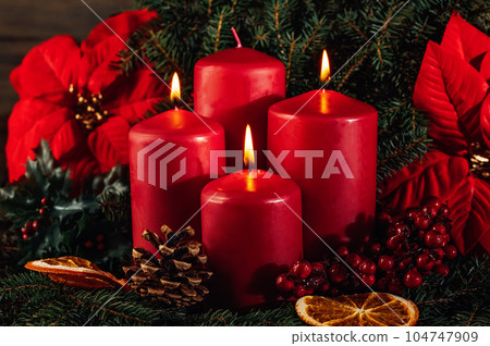 Three burning Red advent candles in advent wreath decoration on wooden dark background. tradition in time before Christmas. xmas lights with christmas fir deco background concept. Festive still life. Three burning Red advent candles in advent wreath decoration on wooden dark background. tradition in time before Christmas. xmas lights with christmas fir deco background concept. Festive still life. 104747909