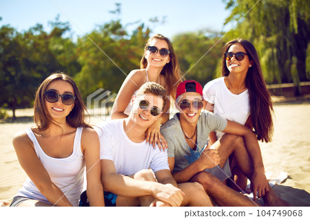 Group of friends hanging out with beer at the beach. Excellent sunny weather. Beautiful figures. 104749068