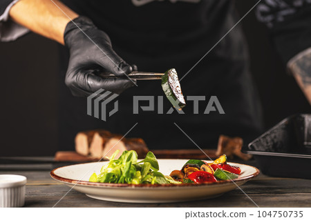 Chef putting fried zucchini Chef putting fried zucchini 104750735