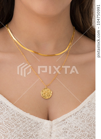 Young woman wearing a butterfly and a snake chain necklace. Young woman wearing a butterfly and a snake chain necklace. 104750991