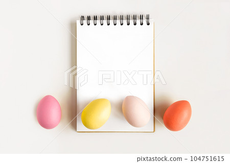 Notebook with Easter Eggs. Spiral notepad on spring white background. Top view of open writing pad with blank page, office flat lay. Easter Mock Up Notebook with Easter Eggs. Spiral notepad on spring white background. Top view of open writing pad with blank page, office flat lay. Easter Mock Up 104751615