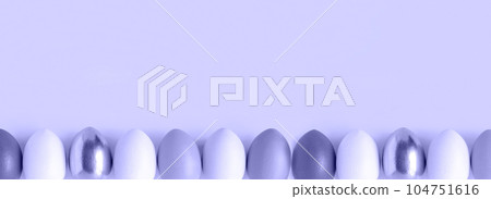 Easter banner with colorful Easter Egg in a row. Border over a violet background. Above view with copy space. Easter decorated eggs frame. Happy Easter card. Top view, flatlay Easter banner with colorful Easter Egg in a row. Border over a violet background. Above view with copy space. Easter decorated eggs frame. Happy Easter card. Top view, flatlay 104751616