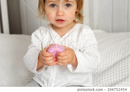 Cute baby girl playing tactile knobby balls. Young child hand plays sensory massage ball. Enhance the cognitive, physical process. Brain development. Support for Children with ADHD, autism, fidgeting Cute baby girl playing tactile knobby balls. Young child hand plays sensory massage ball. Enhance the cognitive, physical process. Brain development. Support for Children with ADHD, autism, fidgeting 104752454