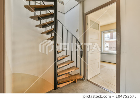 a staircase leading to the second floor in a home with white walls and beige carpeting, there is an open door that leads a staircase leading to the second floor in a home with white walls and beige carpeting, there is an open door that leads 104752573