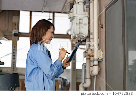 Woman in work clothes Inspection Meter reading 104752888