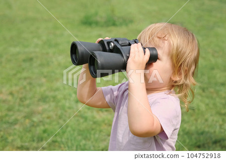 Little girl using binoculars in a forest. 2 years kid looking ahead. Smiling baby with spyglass. Adventure, Imagination, travel concept. Freedom, vacation. Happy child playing outdoor in summer field Little girl using binoculars in a forest. 2 years kid looking ahead. Smiling baby with spyglass. Adventure, Imagination, travel concept. Freedom, vacation. Happy child playing outdoor in summer field 104752918