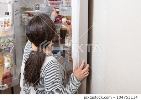 [A housewife takes out a pickled plum from the refrigerator] 104753114