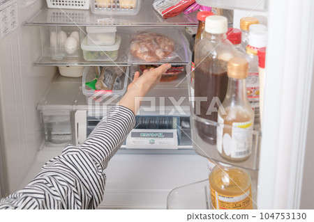 [Housewife serving chicken seasoned for deep-frying from the refrigerator] 104753130