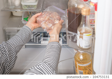 [Housewife serving chicken seasoned for deep-frying from the refrigerator] 104753131