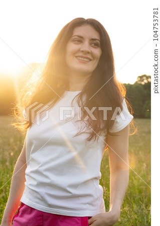 Dreamy pensive 35-year-old brunette woman in nature. The concept of unity with nature, feminine energy. 104753781