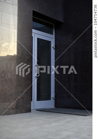 The glass door to the office building. Modern doors. The glass door to the office building. Modern doors. 104754736